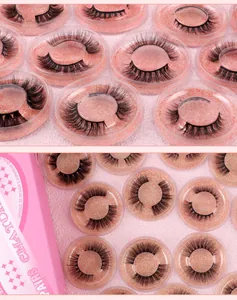 Macro view of 3D layered false eyelashes on pink glitter trays in clear round boxes