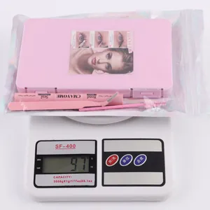 Kit d'extension de cils DIY avec pince et adhésif sur une balance numérique rose