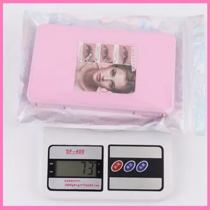 Detailed view of individual cluster lashes in iridescent packaging on a scale weighing 73g