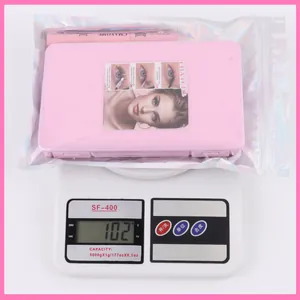 DIY eyelash extension kit with glue and tweezers in holographic packaging on a scale