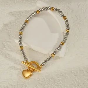 Zweifarbiges Perlenarmband aus Gold und Silber mit Knebelverschluss und Herzanhänger