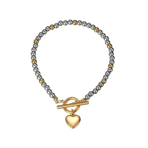Poliertes Silber- und 18K Gold-Perlenarmband mit T-Verschluss und Herzanhänger