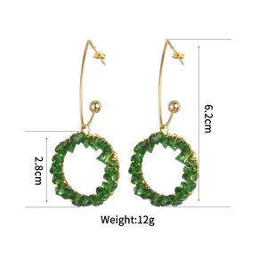 Detail shot of green crystal hoop earrings showing 6.2cm length and 2.8cm diameter