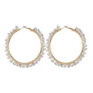 Gold wire wrapped hoop earrings featuring clear faceted crystal beads on white background