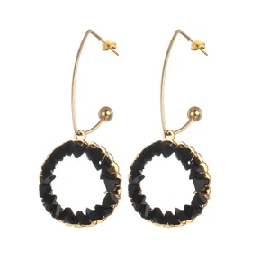 Golden hoop earrings with black faceted beads in a modern dopamine-inspired geometric design