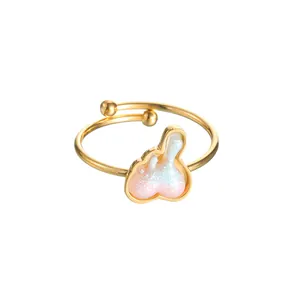 Detail of adjustable gold ring featuring a gradient pink-blue glitter heart motif
