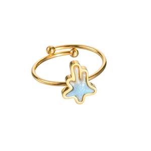 Detailed macro of gold adjustable star ring with light blue glitter resin inlay