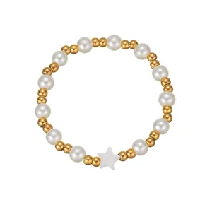 Détail du bracelet de perles blanches et billes dorées avec pendentif étoile sur blanc
