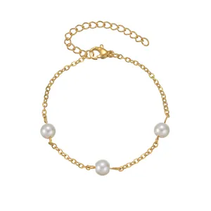 Détail de la chaîne en acier plaqué or 18K avec trois perles blanches et fermoir mousqueton