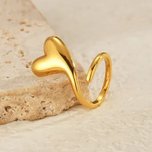 Polished 18K gold plated heart open ring on stone display stand with minimalist design