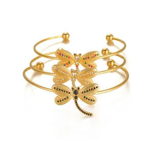 Ensemble de bracelets libellule dorés avec strass colorés sur fond blanc pur