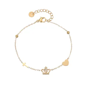 Detailed view of gold stainless steel bracelet with crown, cross, and heart charms