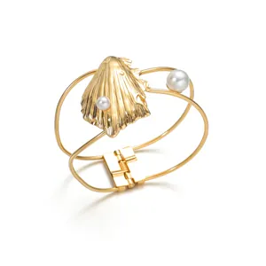 Detailansicht eines goldenen Muschelarmbands mit Perlen und hohlgeformtem Reifdesign