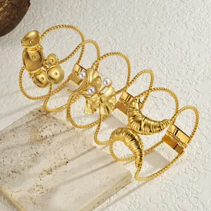 Drei elegante vergoldete Edelstahlarmbänder mit Perlenakzenten und modernem Cut-out-Design