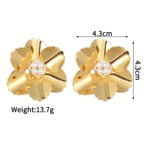 Boucles d'oreilles fleurs vintage en or 18K avec perles sur un fond blanc neutre