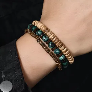 Detailopname van gestapelde boho herenarmbanden met houten kralen en turquoise stenen