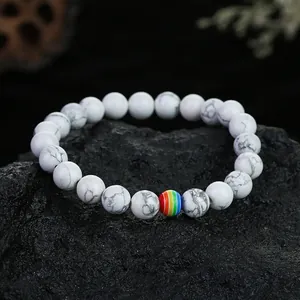 Nahaufnahme von 8mm weißen Türkis-Perlenarmband auf einer rustikalen schwarzen Steinfläche