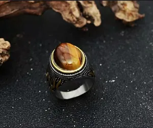 Macro detail of vintage tiger eye ring with flame accents on textured silver band