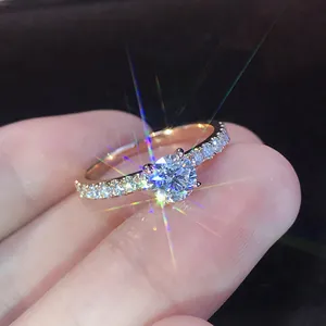 Anillo solitario de oro rosa con engaste de cuatro garras y banda con pavé