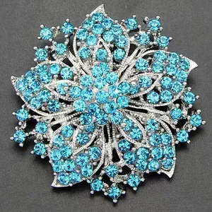 Close-up of vintage flower brooch with light blue rhinestones and silver-tone finish
