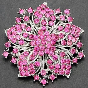 Detailed close-up of a silver floral brooch with shimmering pink rhinestones