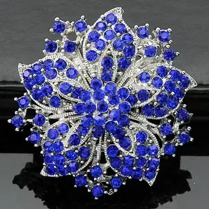 Macro detail of silver floral brooch with multi-layered dark blue sparkling rhinestones