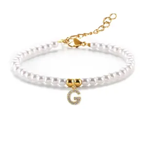 Detail van een 3-4mm parelarmband met gouden G-letterhanger en fonkelende zirkonia steentjes