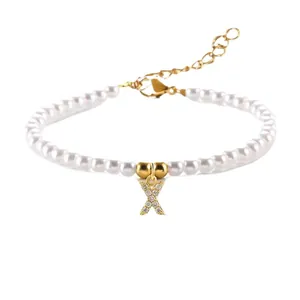 Elegante parelarmband met gouden letter X-hanger en sprankelende zirkoniasteentjes