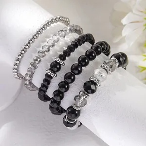 Vijfdelige elastische armbandset met zwarte kristallen en zilveren kralen op standaard