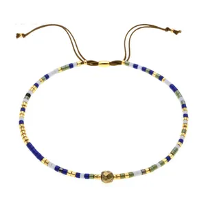 Bracciale bohémien con perline blu e dorate e chiusura a cordoncino regolabile