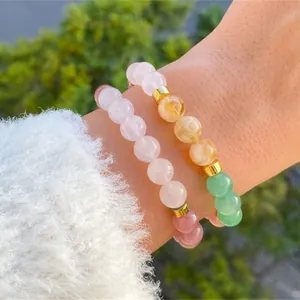Detailed view of natural amethyst and citrine beaded bracelets on a model's wrist