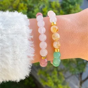 Close-up of stacked natural amethyst and citrine beaded bracelets with gold spacers