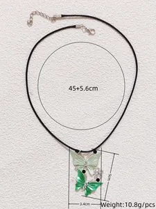 Detail view of butterfly pendant with green wings and dimensions 5cm by 3.4cm on black cord