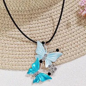 Detail view of double blue butterfly pendants with rhinestones on black cord