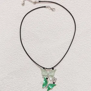Detail of green butterfly pendants on black cord necklace with sparkling rhinestones