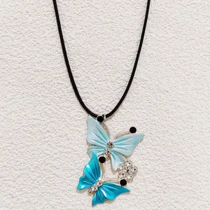 Detail of blue double butterfly pendant with rhinestones on a black cord necklace