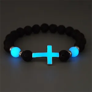 Luminous cross beads and black volcanic lava stones on a glowing bracelet for women