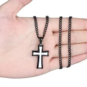 Detail of a minimalist black and white titanium steel cross pendant held in hand