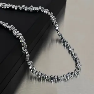 Close-up of metallic irregular pebble-shaped beads with high mirror luster and cold industrial style