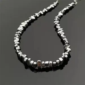 Close-up of irregular silver metal beads with high-polish finish and adjustable chain