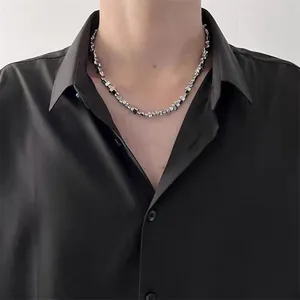 Detail of irregular silver metal beads and black stone beads on minimalist men's necklace
