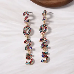 Detalle macro de pendientes 2025 con cristales de colores sobre aleación dorada