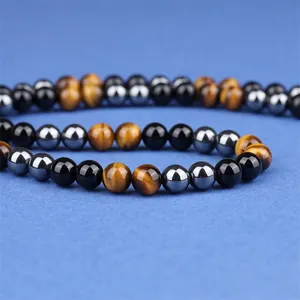 Handgemaakte kralenarmband met tijgeroog, obsidiaan en hematiet op blauwe stof