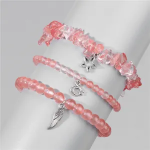 Detailed set of three pink crystal stretch bracelets with star, moon and wing pendants