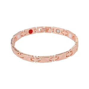 Bracelet de magnétothérapie en or rose avec maillons en croix et pierres énergétiques