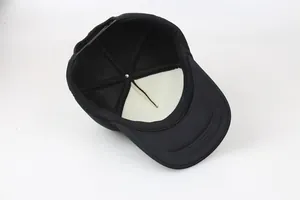 Detail view of the black trucker hat interior with foam padding and plastic snapback closure