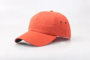 Detail of orange safety bump cap with metal ventilation eyelets and cotton twill fabric