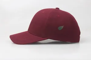 Detail shot of a dark red cotton twill baseball cap with six-panel design and curved brim