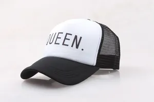 Detail of a black and white trucker hat featuring a bold black QUEEN. printed text design
