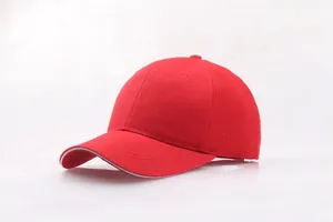 Detail einer roten Baumwoll-Basecap mit weißem Sandwich-Schirm und passendem Knopf